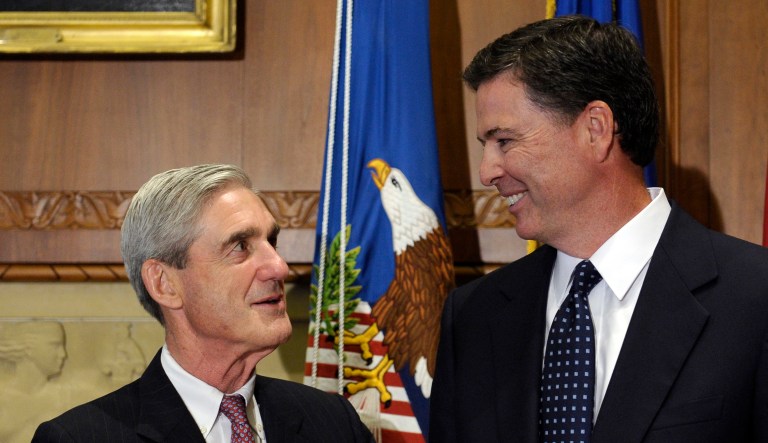 FILE - In this Sept. 4, 2013, file photo, then-incoming FBI Director James Comey talks with outgoing FBI Director Robert Mueller before Comey was officially sworn in at the Justice Department in Washington.
