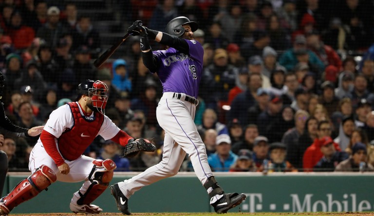 Colorado Rockies' Charlie Blackmon follows through on his two-run home run during the eighth inning of a baseball game against the Boston Red Sox Tuesday, May 14, 2019, at Fenway Park in Boston.