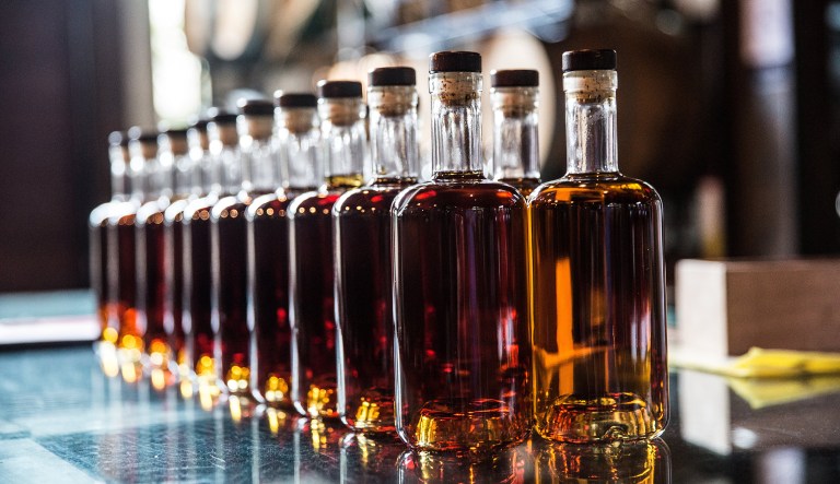 Bottles of aged rum sit on a table prior to labeling at the Samai distillery in Phnom Penh, Cambodia, on Tuesday, July 24, 2018.