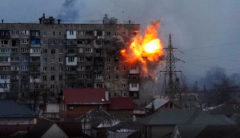 An explosion is seen in an apartment building on Friday, March 11, 2022, in Mariupol, Ukraine,
