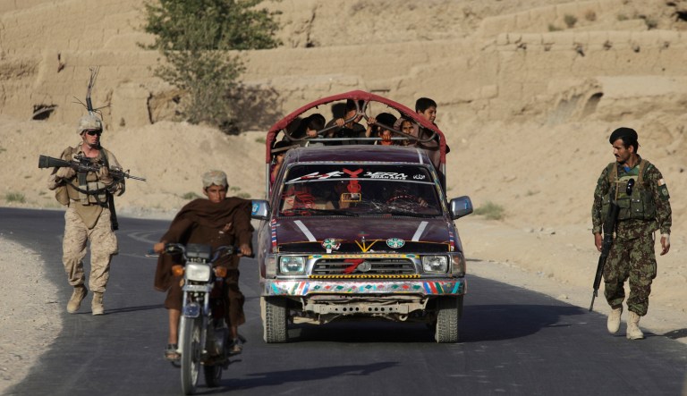 A U.S. Marine from Charlie Company, 1/5 Marines, and an Afghan National Army soldier walk along a busy roadway on a joint patrol in Sangin, Helmand province, southern Afghanistan, Monday Sept. 5, 2011.