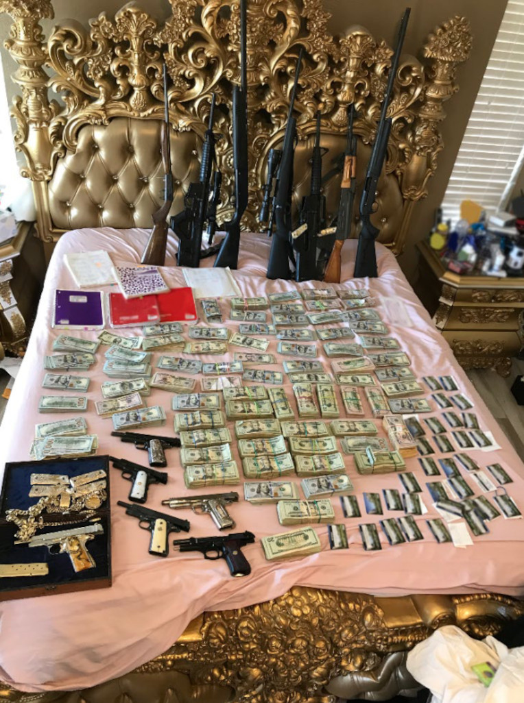 Money, firearms, and other seized items are seen in this picture from the Labor Deparment's Office of Inspector General.