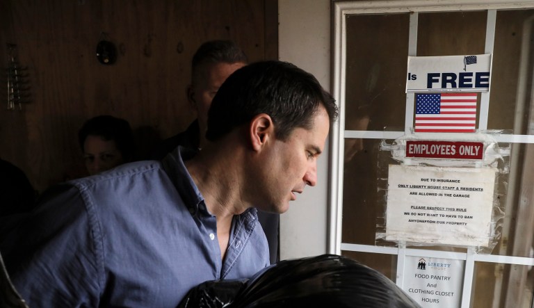 Democratic presidential candidate Rep. Seth Moulton, D-Mass,, carries a bag of donated clothing during a campaign event held at Liberty House in Manchester, N.H. Tuesday, April 23, 2019.