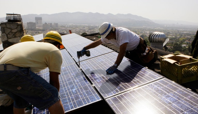 FILE - In this March 23, 2010, file photo, installers from California Green Design install solar electrical panels on the roof of a home in Glendale, Calif. The Obama administration announced a plan Tuesday, July 19, 2016, to help middle-class and low-income communities put solar panels on their roofs. White House officials said energy upgrades can be made with no upfront costs, but homeowners will gradually pay back the cost through their property tax bills.