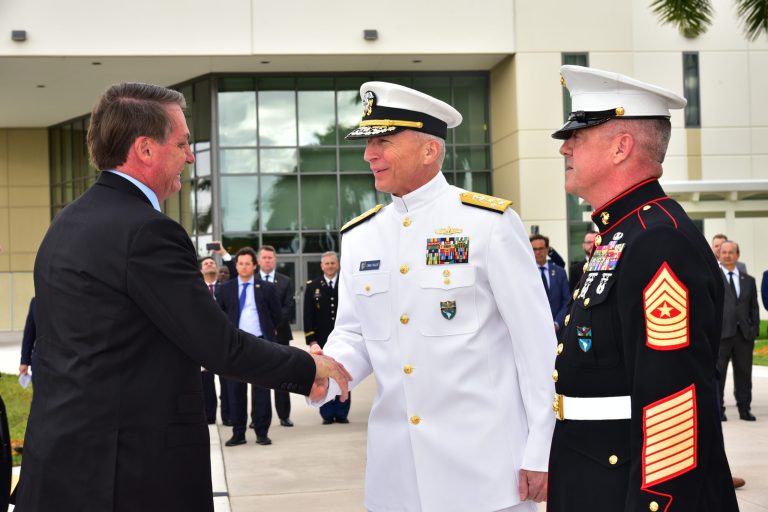 MIAMI (March 8, 2020) -- Brazilian President Jair Bolsonaro arrives at U.S. Southern Command headquarters and is greeted by SOUTHCOM Commander, Navy Adm. Craig Faller, and Command Senior Enlisted Leader, Marine Sgt. Maj. Bryan K. Zickefoose. Bolsonaro's press chief, Fabio Wajngarten, who tested positive for COVID-19, is visible in the background at left with a blue tie.