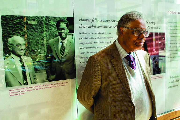 Thomas Sowell stands next to a photograph of himself with the economist Milton Friedman. Sowell is currently the Rose and Milton Friedman Senior Fellow on Public Policy at the Hoover Institution at Stanford University. (Photo by Darius Frye)