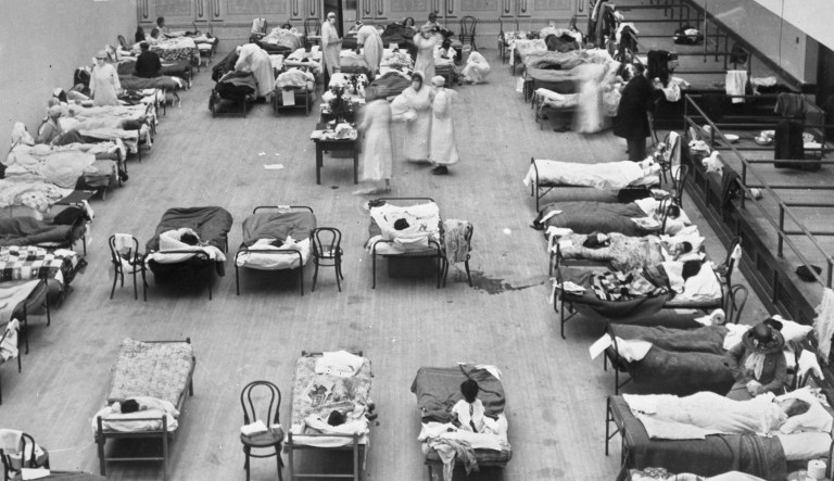 1918 flu epidemic: the Oakland Municipal Auditorium in use as a temporary hospital. The photograph depicts volunteer nurses from the American Red Cross tending influenza sufferers in the Oakland Auditorium, Oakland, California, during the influenza pandemic of 1918.