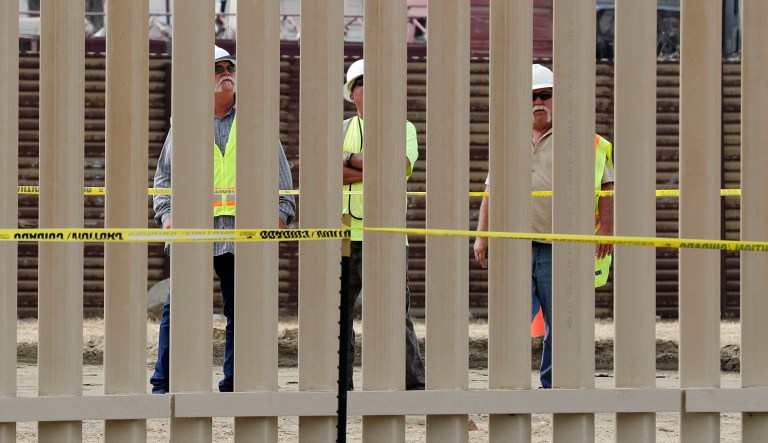 FILE - In this Oct. 19, 2017 file photo, crews work on a border wall prototype near the border with Tijuana, Mexico, in San Diego. A U.S. official says recent testing of prototypes of President Donald Trump's proposed wall with Mexico found their heights should stop border crossers. U.S. tactical teams spent three weeks trying to breach and scale the models in San Diego. An official with direct knowledge of the results said they point to see-through steel barriers topped by concrete as the best design. The official spoke to The Associated Press on condition of anonymity because the information is not authorized for release.