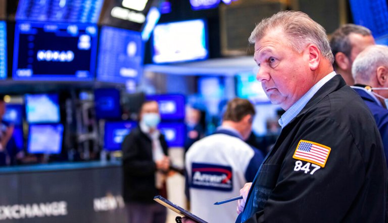 The S&P 500 entered a bear market on Monday as the Federal Reserve prepares to hike interest rates. In this photo provided by the New York Stock Exchange (NYSE), trader Neil Tapia is shown working on the NYSE trading floor.