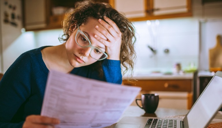 Female reading her bill papers, looking stressed
