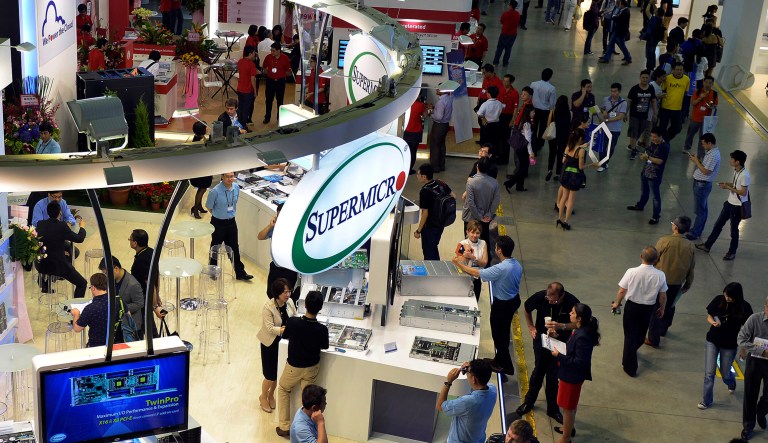 Visitors are seen walking past trade stands, including the Supermicro booth, during the Computex Taipei 2014 expo at the Taipei Nangang Exhibition Center in Taipei, Taiwan, on Tuesday, June 3, 2014.
