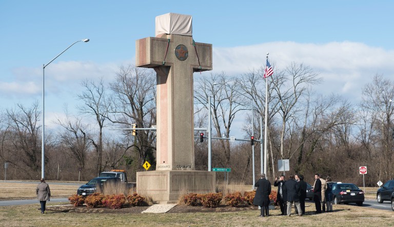 In this Feb. 13, 2019 file photo, visitors walk around the 40-foot Maryland Peace Cross dedicated to World War I soldiers in Bladensburg, Md. The Supreme Court says the World War I memorial in the shape of a 40-foot-tall cross can continue to stand on public land in Maryland.