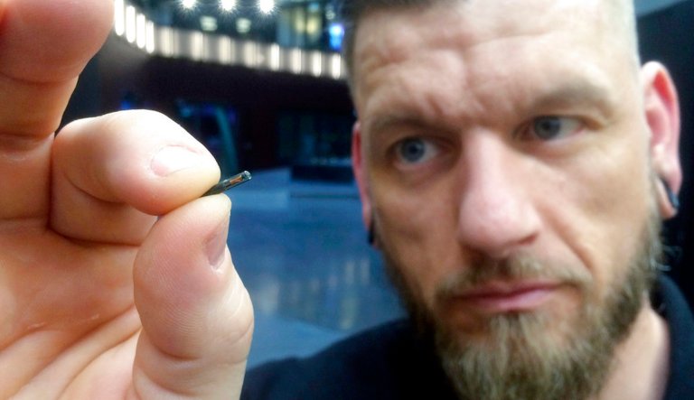 In this March 14, 2017, file photo, Jowan Osterlund from Biohax Sweden, holds a small microchip implant, similar to those implanted into workers at the Epicenter digital innovation business centre during a party at the co-working space in central Stockholm. 