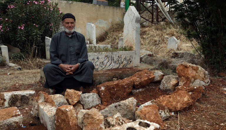 Mohammed Hassan Masto sits next to the grave of his brother Lutfi, who was killed on Wednesday, May 3,  in a U.S. military strike, in the village of Qorqanya, a rural area in northern Idlib province, Syria, Sunday, May 7, 2023. 