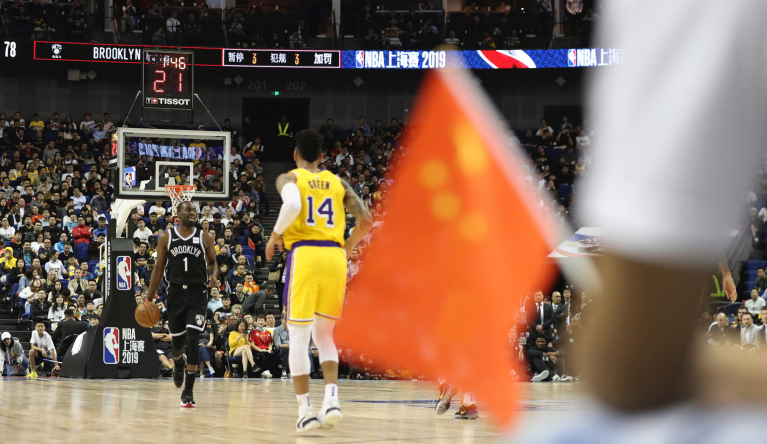 Brooklyn Nets' Theo Pinson, left, drives against Los Angeles Lakers' Danny Green near a Chinese national flag during a preseason NBA basketball game at the Mercedes Benz Arena in Shanghai, China, Thursday, Oct. 10, 2019. In response to the NBA defending Daryl Morey's freedom of speech, Chinese officials took it away from the Los Angeles Lakers and Brooklyn Nets. All of the usual media sessions surrounding the Lakers-Nets preseason game in Shanghai on Thursday â including a scheduled news conference from NBA Commissioner Adam Silver and postgame news conferences with the teams â were canceled. It was the latest salvo in the rift between the league and China stemming from a since-deleted tweet posted last week by Morey, the general manager of the Houston Rockets. 
