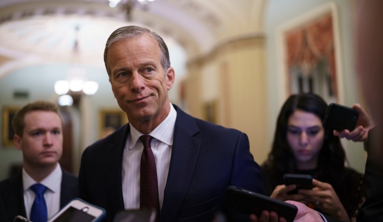 Senate Minority Whip John Thune, R-S.D., speaks to reporters just off the Senate floor as a bipartisan group of lawmakers negotiate a plan to pay for an estimated $1 trillion compromise plan, at the Capitol in Washington.