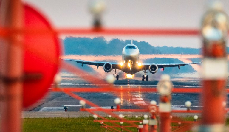 A passenger jet is framed in the runway guidance lights during takeoff from Ronald Regan National Airport in Washington, Friday, June 29, 2018 on what is expected to be a very busy travel weekend.