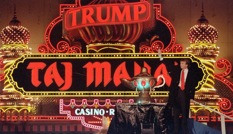 In this April 5, 1990 file photo, Donald Trump stands next to a genie lamp as the lights of his Trump Taj Mahal Casino Resort mark its grand opening in Atlantic City, N.J.