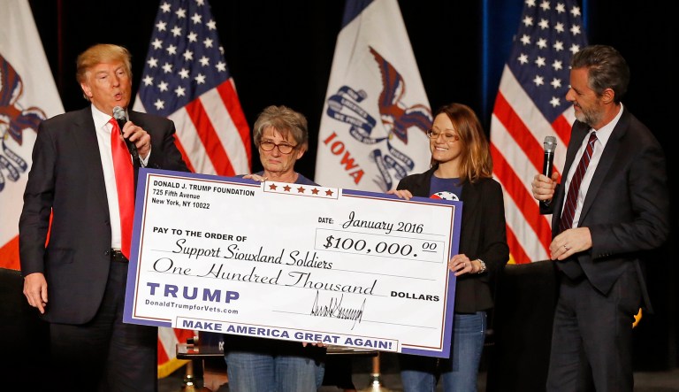In this Jan. 31, 2016 file photo, Donald Trump, left, stages a check presentation with an enlarged copy of a $100,000 contribution from the Donald J. Trump Foundation to Support Siouxland Soldiers during a campaign event in Sioux City, Iowa., during Trump's run for president. New York Attorney General Barbara Underwood filed a lawsuit Thursday June 14, 2018, accusing Trump of illegally using his charitable foundation to pay legal settlements related to his golf clubs and to bolster his presidential campaign with Foundation disbursements such as this one in Iowa. Also pictured is Jerry Falwell, Jr., right, president of Liberty University.