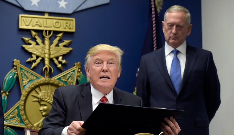 FILE - In this Jan. 27, 2017 file photo, President Donald Trump, left, with Defense Secretary James Mattis, right, watching, explains the executive action on extreme vetting that he is about to sign at the Pentagon in Washington. American forces were perched high on the top of the Bashiq Mountain, calling in airstrikes that pounded Islamic State militants. Down below, Kurdish forces rolled past to recapture in the ancient city of Sinjar.