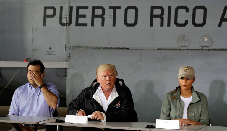 President Donald Trump talks about recovery efforts after he and first lady Melania Trump arrived at Luis Muniz Air National Guard Base to survey hurricane damage, Tuesday, Oct. 3, 2017, in San Juan, Puerto Rico, as Puerto Rico Gov. Ricardo RossellÃ³, left, looks on.