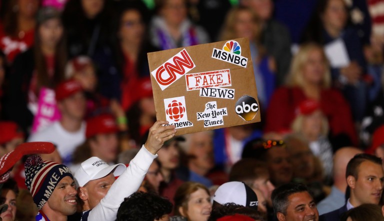 An audience member holds a fake news sign during a President Donald Trump campaign rally in Washington Township, Mich., Saturday, April 28, 2018.