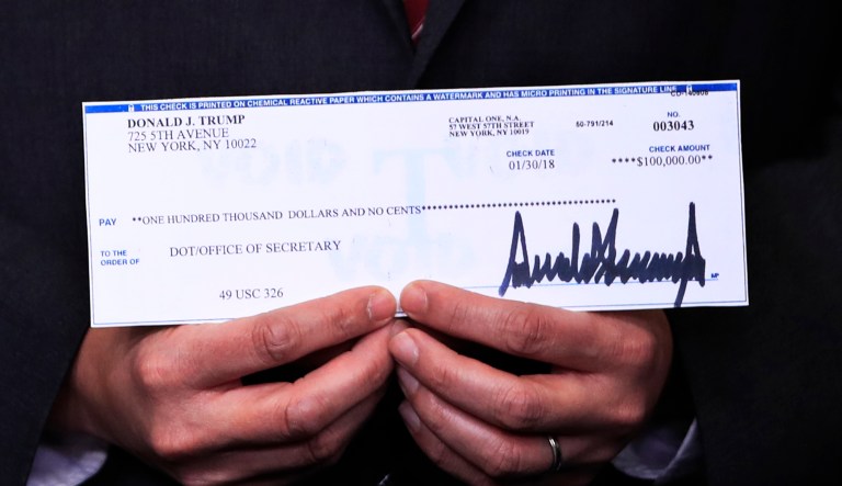 A $100,000 check from President Donald Trump's quarterly salary, donated to the Department of Transportation, is presented during the daily press briefing in the Brady press briefing room at the White House, in Washington, Tuesday, Feb. 13, 2018.