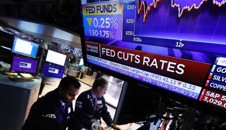 A television screen on the floor of the New York Stock Exchange shows the rate decision of the Federal Reserve, Wednesday, Oct. 30, 2019. The Federal Reserve has cut its benchmark interest rate for the third time this year to try to sustain the economic expansion in the face of global threats.