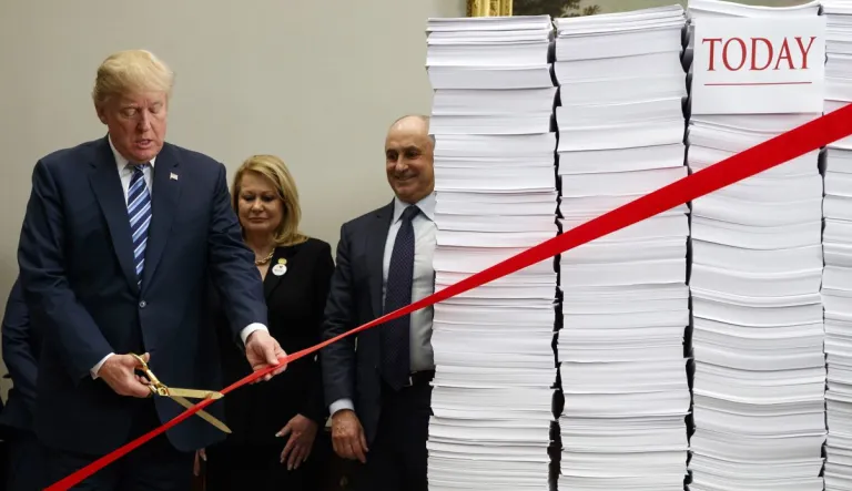 President Trump cuts a ribbon during an event on federal regulations in the Roosevelt Room of the White House, Thursday, Dec. 14, 2017, in D.C. 