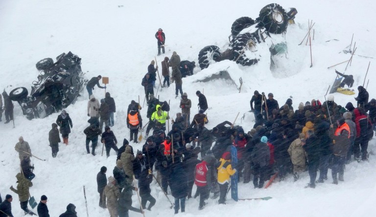 Emergency service members work in the snow around overturned vehicles, near the town of Bahcesaray, Van province, eastern Turkey, on Wednesday. An avalanche slammed into a mountain road in the province, which borders Iran, wiping out a huge team of rescue workers sent to find two people missing in an earlier avalanche.