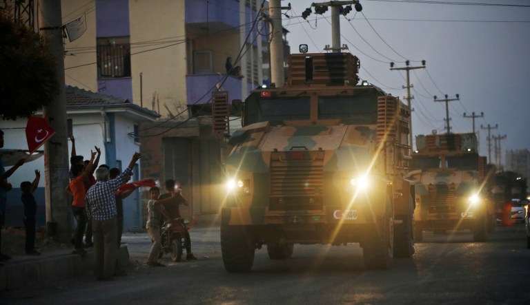 Shortly after the Turkish operation inside Syria had started, local residents cheer and applaud as a convoy of Turkish forces vehicles is driven through the town of Akcakale, Sanliurfa province, southeastern Turkey, at the border between Turkey and Syria, Wednesday, Oct. 9, 2019. 