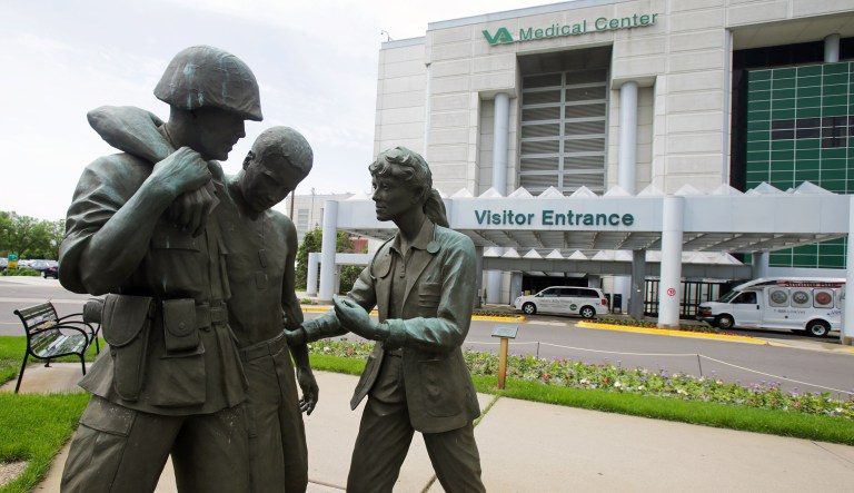 Three statues portraying a wounded soldier being helped, stand on the grounds of the Minneapolis VA Hospital, Monday, June 9, 2014. An audit of 731 VA hospitals and clinics found that a 14-day goal for seeing first-time patients was unattainable given increasing demand for health care. The VA said Monday it was abandoning the scheduling goal. 