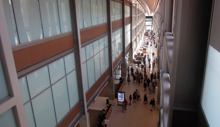 Visitors stroll through a long, glass-walled corridor that connects a dozen buildings at the new Rocky Mountain Regional VA Medical Center in Aurora, Colo., after a ribbon-cutting ceremony at the hospital Saturday, July 21, 2018.