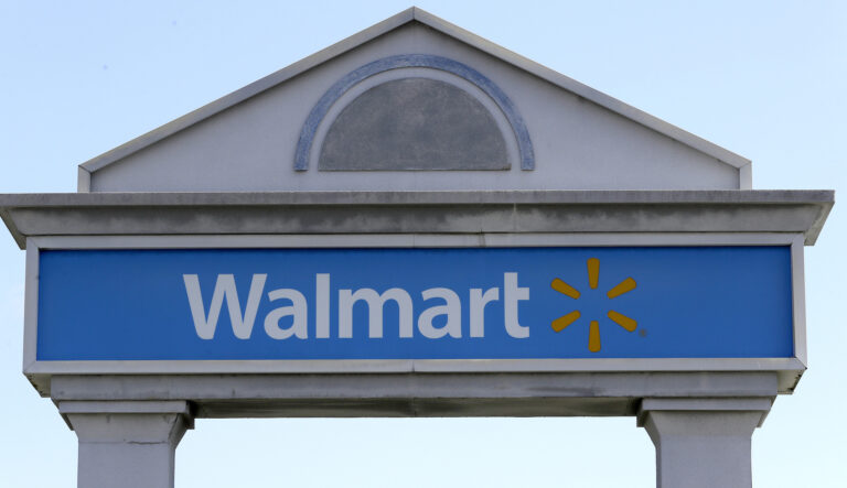 FILE - In this Tuesday, Sept. 3, 2019, file photo, a Walmart logo forms part of a sign outside a Walmart store, in Walpole, Mass. Walmart is rolling out a health care pilot program for its employees that will come up with a curated list of high quality providers but offer fewer choices than under the current plan.
