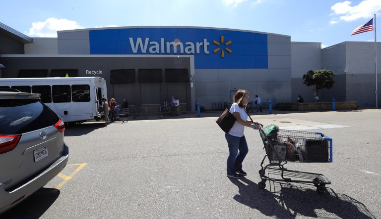 A customer pushes a shopping cart Tuesday, Sept. 3, 2019, outside a Walmart store, in Walpole, Mass. 