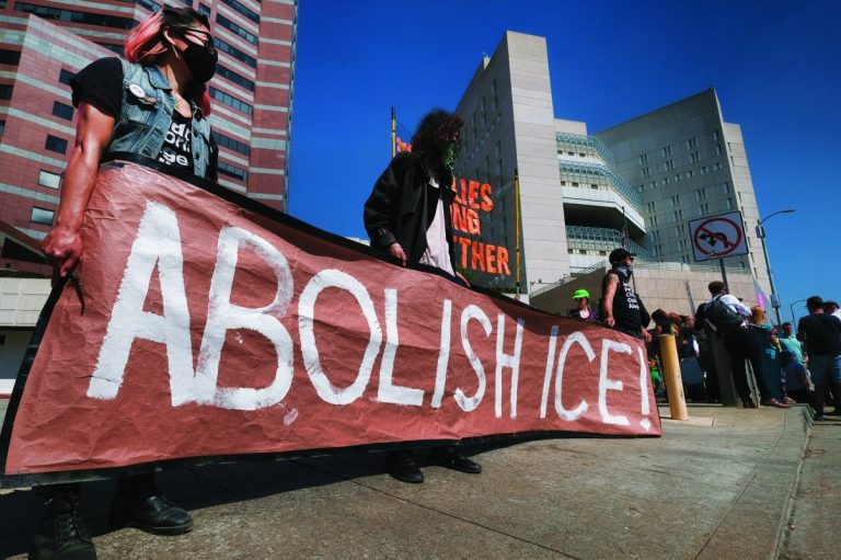 Protesters display a sign that reads "Abolish ICE"