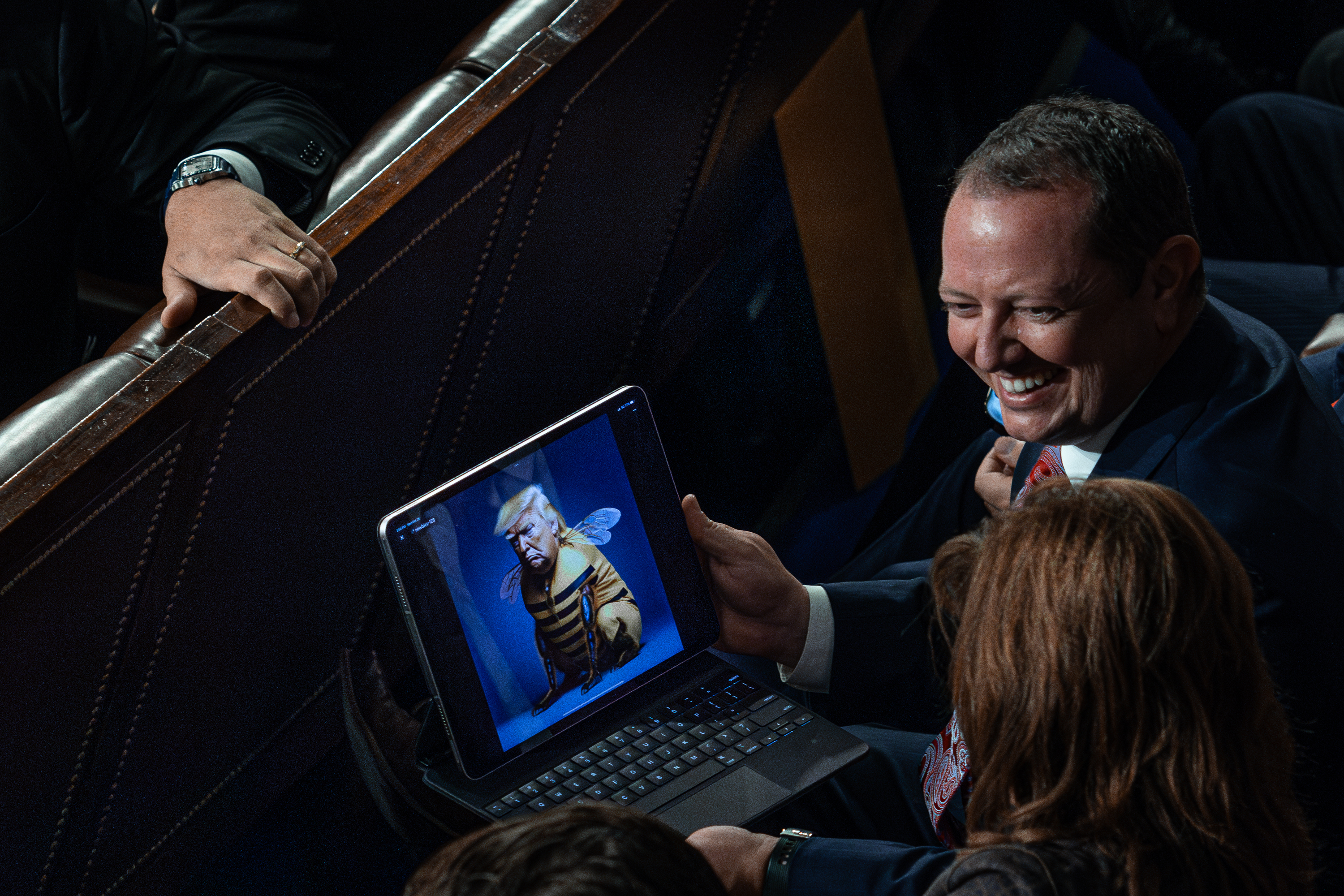 Rep. Eric Burlison (R-MO) shows fellow lawmakers an illustration of Donald Trump dressed in a bee costume, after   Mike Johnson (R-LA) was elected speaker on Wednesday, October 25, 2023. 
