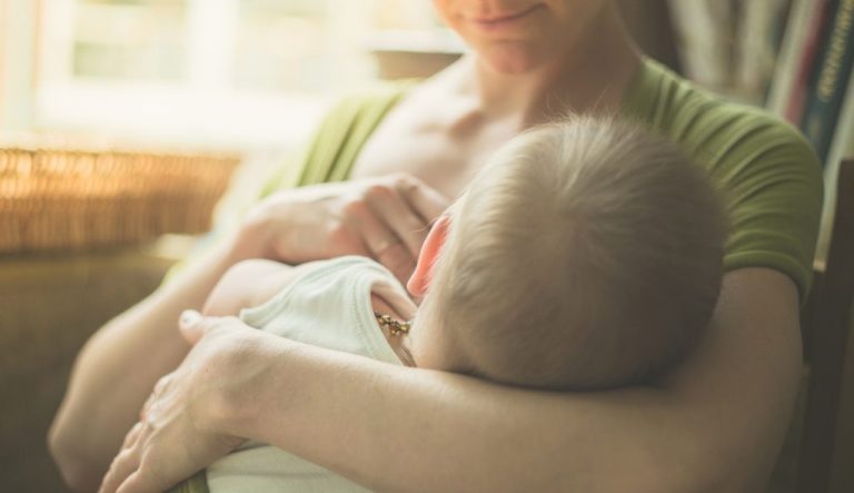 A woman breastfeeding a child.
