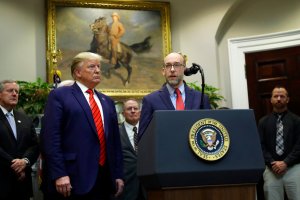 President Donald Trump listens as Office of Management and Budget acting Director Russell Vought speaks.