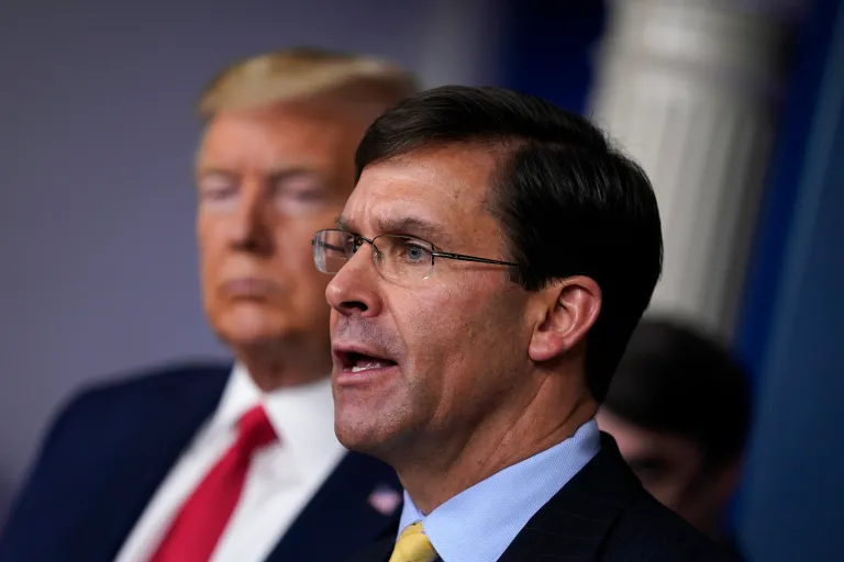In this March 18, 2020, file photo, Defense Secretary Mark Esper speaks as President Donald Trump listens during press briefing (AP Photo/Evan Vucci, File)