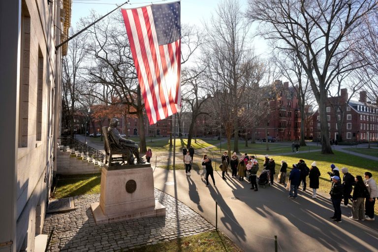 People take photographs near a John Harvard statue, left, Tuesday, Jan. 2, 2024, on the campus of Harvard University, in Cambridge, Massachusetts Harvard University President Claudine Gay resigned Tuesday amid plagiarism accusations and criticism over testimony at a congressional hearing where she was unable to say unequivocally that calls on campus for the genocide of Jews would violate the school's conduct policy.