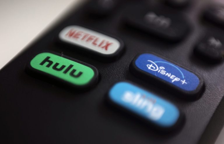 The logos for streaming services Netflix, Hulu, Disney Plus and Sling TV are pictured on a remote control.