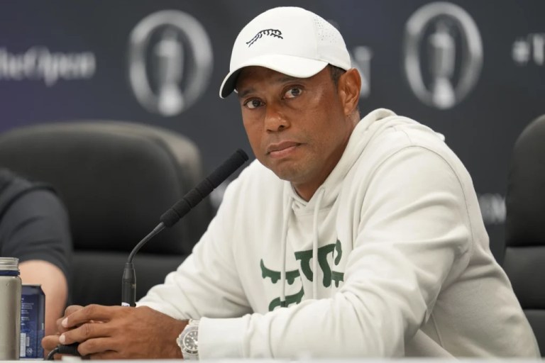 Tiger Woods sitting in front of a microphone