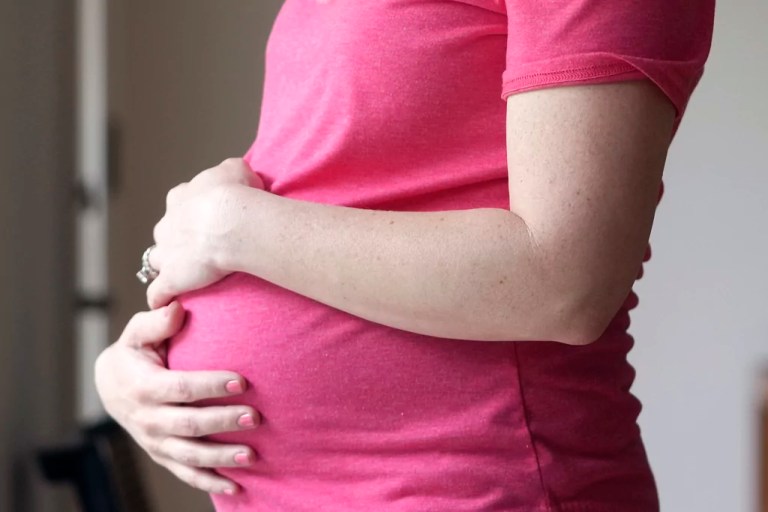 A pregnant woman stands for a portrait in Dallas, May 18, 2023.
