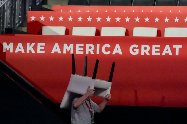 A worker carries a chair during preparations for the Republican National Convention in 2024