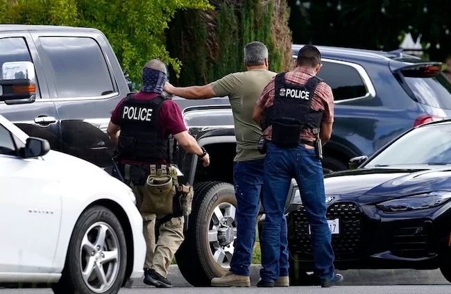 U.S. Immigration and Customs Enforcement agents arrest an immigrant outside his residence during an early morning raid in Duarte, Calif., Monday, June 6, 2022. This weekend, the Biden administration said it would suspend an order prioritizing the arrest and deportation of immigrants considered a threat to public safety and national security in order to comply with a ruling earlier in June 2022 from a Texas judge. Many otherwise law-abiding immigrants living here illegally will now be afraid to leave their homes out of concern they'll be detained. (AP Photo/Damian Dovarganes)