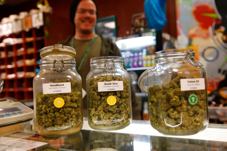 FILE - In this Nov. 27, 2015, file photo, jars of marijuana buds sit on the counter at the Denver Kush Club in north Denver. A coalition that wants to ask Colorado voters to approve higher taxes on recreational marijuana to help children make up for learning losses during the pandemic and address tutoring and other special needs for low-income and disadvantaged children said Wednesday, June 16, 2021, it's been endorsed by former Democratic and Republican governors.