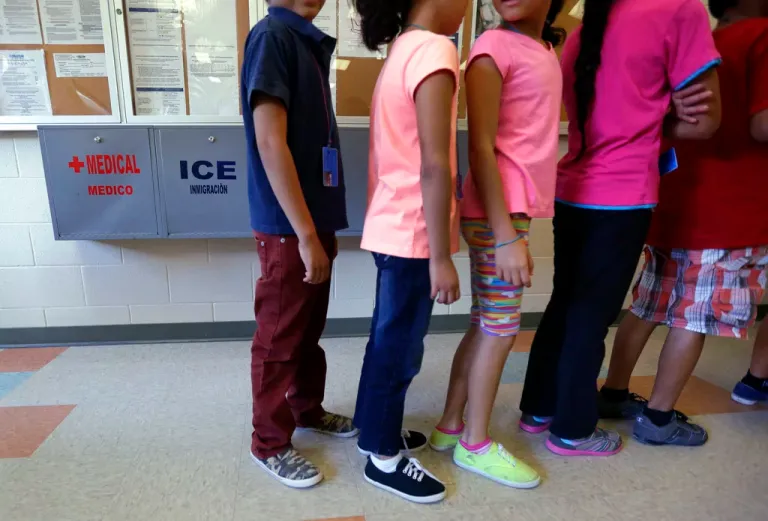 Detained immigrant children line up in the cafeteria at the Karnes County Residential Center, a temporary home for immigrant women and children detained at the border, in Karnes City, Texas. The private prison industry profits from an immigrant detention boom around the country.
