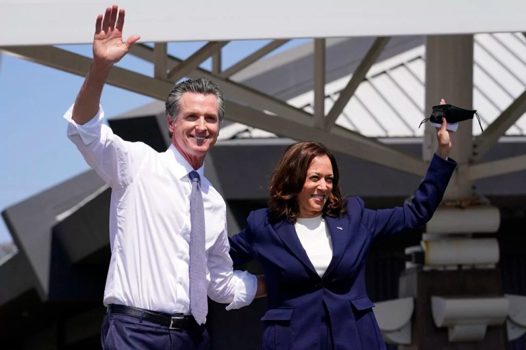 Newsom and Harris wave during a campaign event at the IBEW-NECA Joint Apprenticeship Training Center in San Leandro, California.