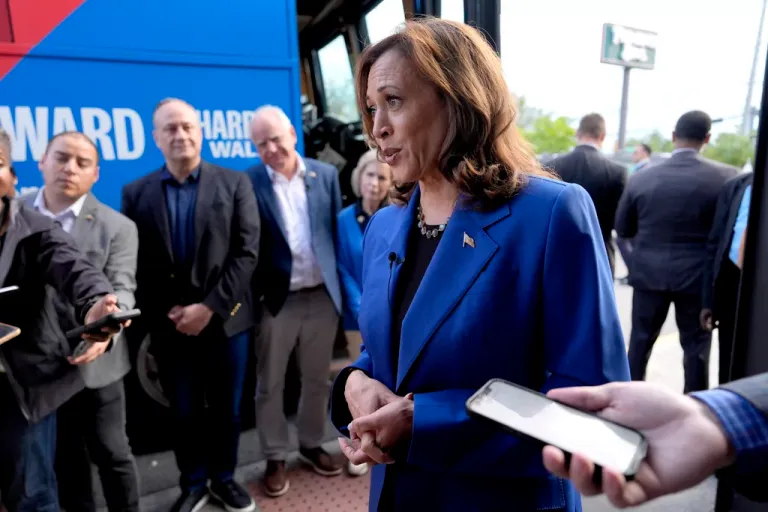 Democratic presidential nominee Vice President Kamala Harris speaks to reporters as second gentleman Doug Emhoff, from third right, Democratic vice presidential nominee Minnesota Gov. Tim Walz and his wife Gwen Walz, listen outside a Primanti Bros. restaurant during a campaign stop, Sunday, Aug. 18, 2024, in Pittsburgh. (AP Photo/Julia Nikhinson)